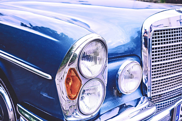 Antiguo coche de época en azul con parrilla y lámparas con mucho cromo
 - Foto, imagen