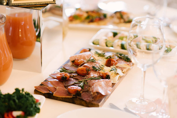 Tavolo con cibo per le vacanze. Snack su una tavola di legno: pane con carne e formaggio, bella porzione, focus selettivo
 - Foto, immagini