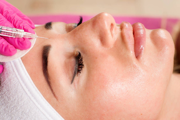 Косметолог руки роблять процедуру краси для жіночого обличчя шприцом. Косметична медицина та хірургія, концепція ін'єкцій краси
 - Фото, зображення