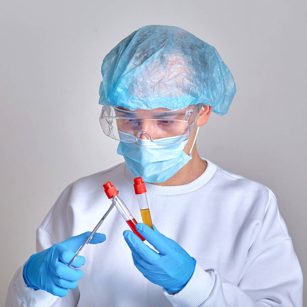 Médecin masqué effectuant un test sanguin pour le coronavirus COVID19, VIH, Ebola ou autre infection dangereuse, maladie. Docteur portrait, fond médical, modèle, papier peint. Maladie coronavirus
  - Photo, image