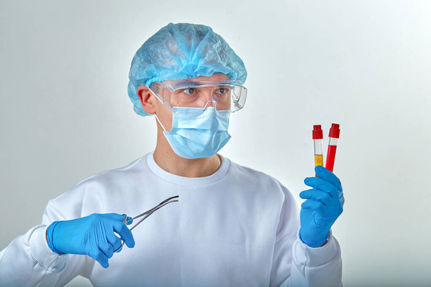 Medico in maschera che esegue esami del sangue per coronavirus COVID19, HIV, ebola o altre infezioni pericolose. Sfondo medico, strumenti, modello, carta da parati. Concetto di malattia di Coronavirus
 - Foto, immagini