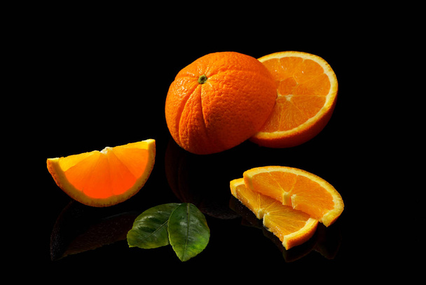 Orangenfrüchte auf schwarzem Hintergrund, isoliert - Foto, Bild