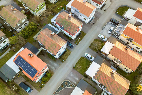Vue aérienne de maisons résidentielles avec des toits rouges et des rues avec des voitures garées dans la zone rurale de la ville. Banlieue tranquille d'une ville européenne moderne. - Photo, image