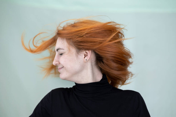 Nahaufnahme Porträt eines hübschen rothaarigen Mädchens mit langen welligen Haaren, die im Wind wehen. - Foto, Bild