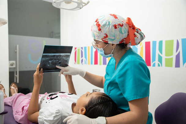 Röntgene bakan kız ve kadın doktorla çocuk diş hekimliği bürosu - Fotoğraf, Görsel