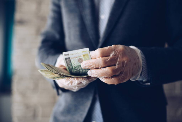 Людина рахує польські злоті гроші банкноти в захисних латексних рукавицях. - Фото, зображення