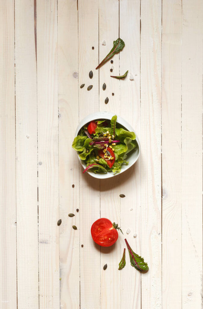 ensalada saludable de hojas de remolacha, cereza, semillas de calabaza y brotes de frijol mungo en un tazón blanco sobre un fondo claro, verticalmente
 - Foto, imagen