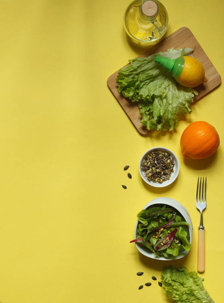 Ingredientes para hacer una ensalada fresca de hojas de remolacha y granos germinados con aceite de linaza y jugo de limón sobre un fondo amarillo con espacio
 - Foto, imagen