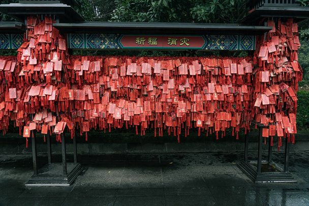 Czerwone modlące się karty życzeń wiszą na tradycyjnym stoisku napisanym w chińskiej Pray Fortune, w świątyni Huayan Si - Zdjęcie, obraz