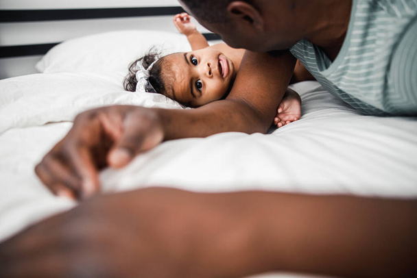 Loving father spending time with newborn daughter at home - Fotó, kép