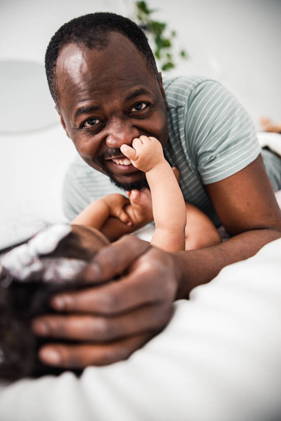 Newborn child touching nose of smiling father - Foto, afbeelding