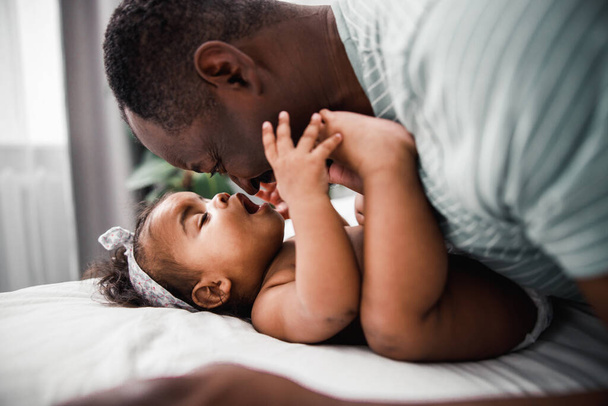 Happy father and cute newborn daughter cuddling at home - Photo, image