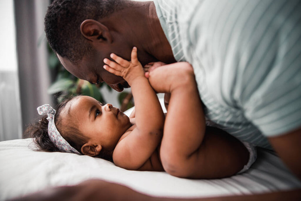 Adorable Afro American baby touching father face - Zdjęcie, obraz