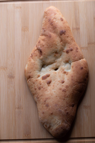 Ψωμί πίτας σε ξύλινη σανίδα. Η Πίτα στον πίνακα. Φωτογραφία από το φαγητό, πίτα ψωμί μαγειρεμένο σε κεφίρ. Υγιεινή τροφή. Αλεύρι σκληρού σίτου - Φωτογραφία, εικόνα