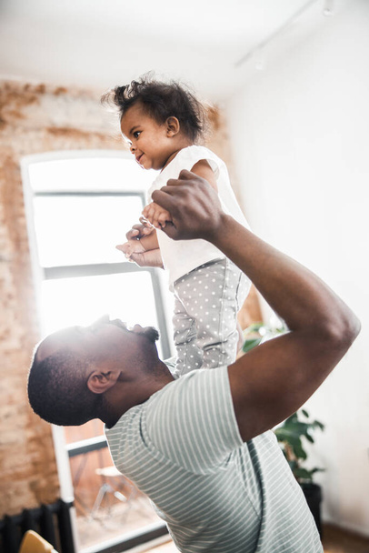 Loving father playing with newborn daughter at home - Fotó, kép