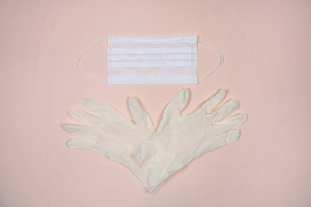 Medical gloves and mask on pink background - Zdjęcie, obraz