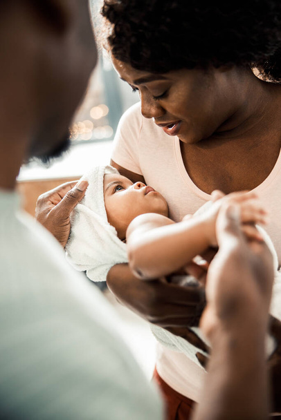 Charming Afro American lady holding baby in her arms - Photo, image