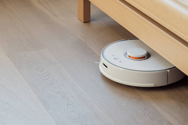 Робот-пылесос выполняет автоматическую очистку квартиры
 - Фото, изображение