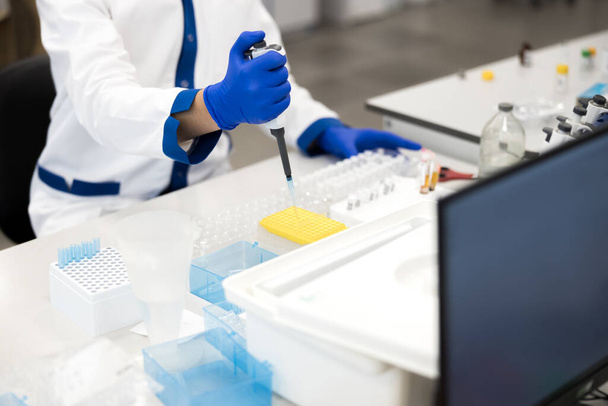 Чоловіча рука дослідника в стерильній рукавичці з використанням лабораторного пробовідбору
 - Фото, зображення