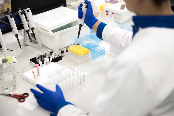 Laboratory technician doing biochemical blood test at work - Фото, зображення