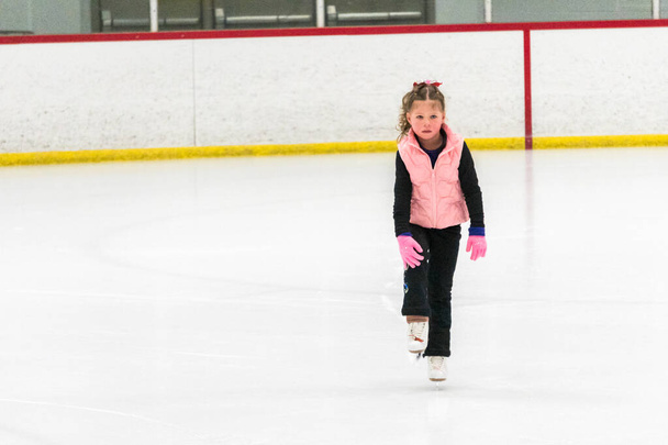 Pequena patinadora praticando seus elementos na prática de patinação artística matinal. - Foto, Imagem