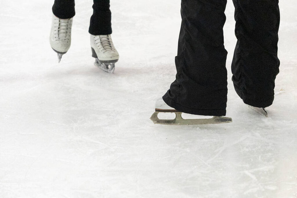 Vista de un patinador artístico y sus pies de entrenador en la práctica de patinaje artístico. - Foto, imagen