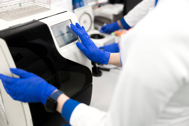 Scientist using advia immunoassay system in laboratory - Foto, afbeelding
