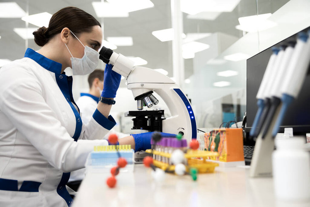 Female researcher working with microscope in laboratory - Fotografie, Obrázek