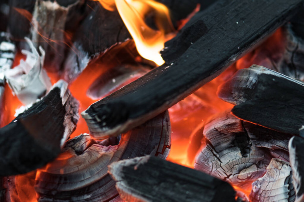 Brasas de carbón ardiendo con fuego y cenizas preparándose para una barbacoa de primavera y verano
 - Foto, imagen