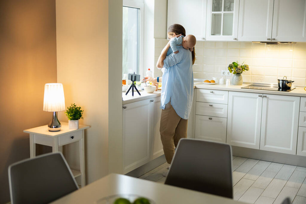 Pretty young lady enjoying time with her kid in the kitchen - Foto, Imagen
