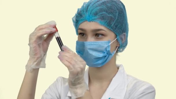 Doctora joven en máscara protectora con tubo de análisis de sangre
. - Metraje, vídeo