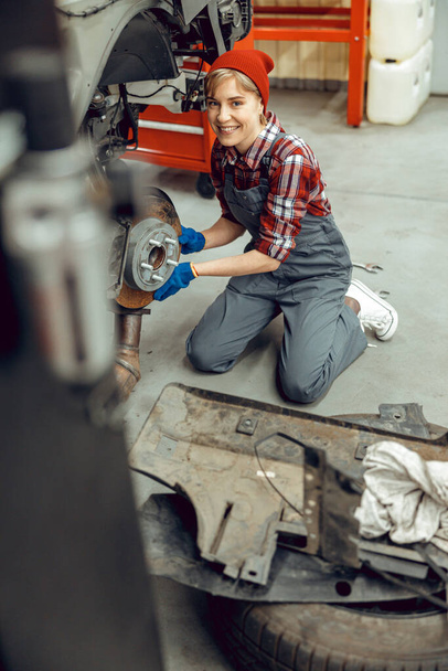 Female mechanic working at a service station - Фото, изображение