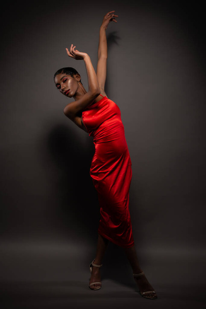 Стройная молодая афроамериканка в узком красном платье
 - Фото, изображение