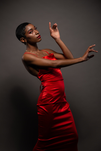 Slender young African American woman in a tight red dress - 写真・画像