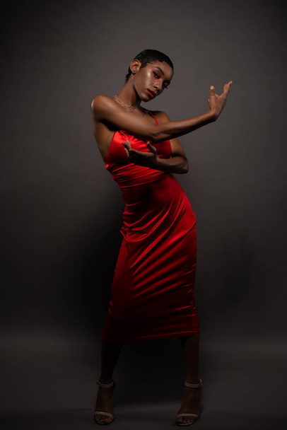 Slender young African American woman in a tight red dress - Fotoğraf, Görsel