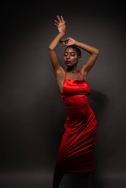 Slender young African American woman in a tight red dress - 写真・画像