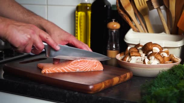 Las manos del hombre cortando salmón en una tabla de madera
 - Imágenes, Vídeo
