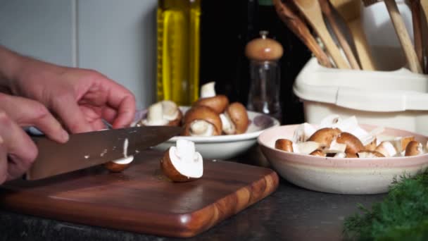 Man 's handen snijden champignons op een houten plank - Video