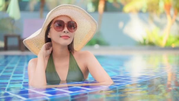 Footage of beautiful young asian woman relax around swimming pool in hotel resort for leisure in vacation - Кадры, видео