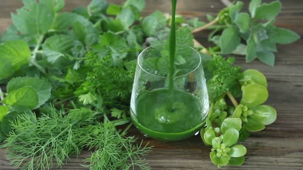 Zöld gyógynövény smoothie a fa barna asztalon - Felvétel, videó