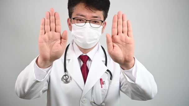 Ağır çekim. Orta yaşlı bir Asyalı doktor elini kaldırdı ve onaylamadığını ifade etti.. - Video, Çekim