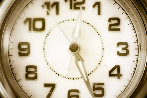 Die alte Uhr, das helle Zifferblatt, die Zeit verging am Nachmittag. Mittagspause, Mitte des Tages, bestimmte Stunde. Gedämpfte Töne, Vintage-Tonung. - Foto, Bild