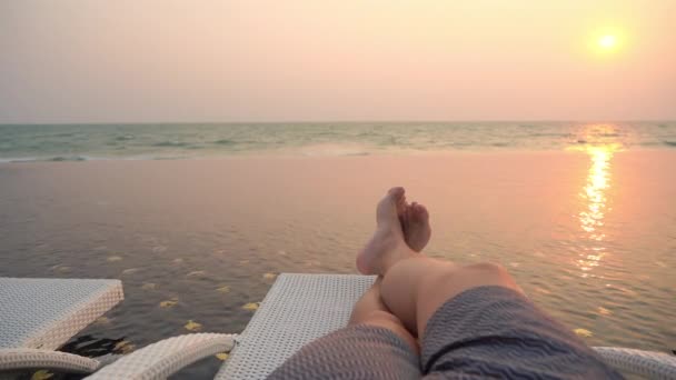 Szelektív fókuszpont a láb körül szabadtéri medence hotel üdülőhely naplementekor vagy napkeltekor szabadidős utazás és nyaralás - Felvétel, videó
