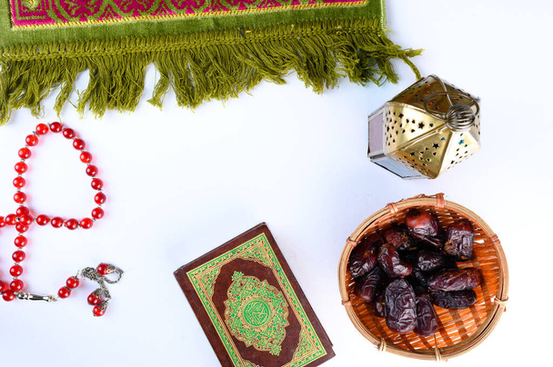 An islamic concept for Ramadhan. Flat lay composition of Lantern, Holy Book Quran, Dates and a tasbih (rosary beads) isolation white background. - Photo, Image