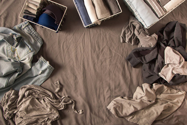 Order in wardrobe. Clothing neatly folded. Grey background. Bedroom, tidying up, cluttering - Fotografie, Obrázek