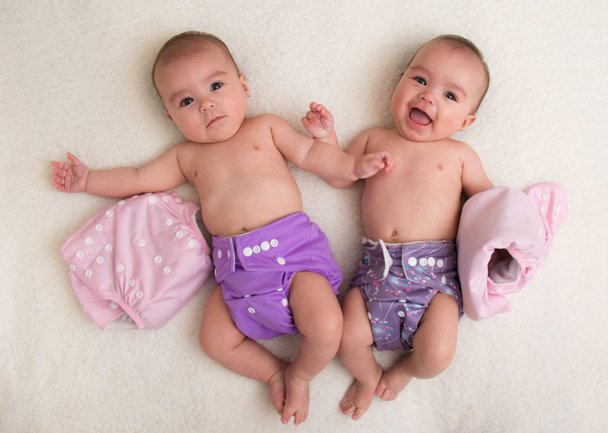 Дитячі близнюки дівчата з тканинним підгузником на ліжку
 - Фото, зображення