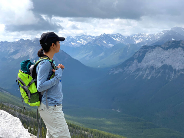 Woman hiking through Canadian Rockies at Mount Rundle in Banff National Park in Alberta Canada - 写真・画像