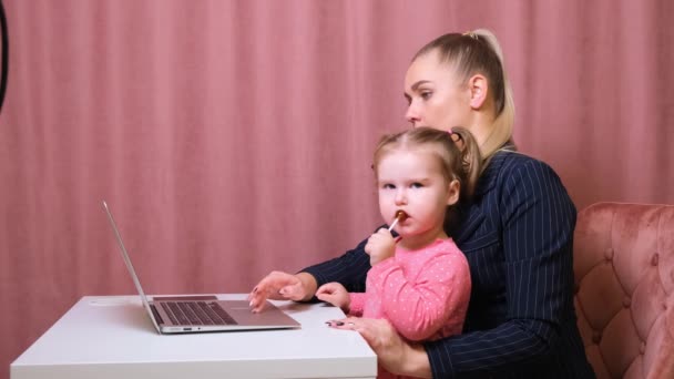 Mamá trabajadora trabaja en casa. Feliz madre e hija sonriendo. Mujer exitosa y un niño lindo usando el ordenador portátil. Trabajo freelancer. Asuntos femeninos. No es fácil, pero ella está a la altura
 - Imágenes, Vídeo