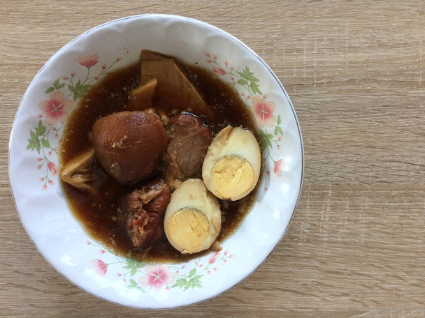 Ovos cozidos no molho doce com carne de porco cozida também conhecida como Kai Pa Lo, cozinha tailandesa deliciosa, vista superior com fundo de madeira
 - Foto, Imagem