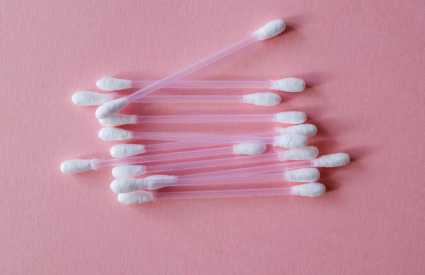 Cotton sticks for hygiene and make-up made from plastic and natural cotton fiber on a pink background. Plastic free, cosmetics concept. Close up. View from above.  - Φωτογραφία, εικόνα